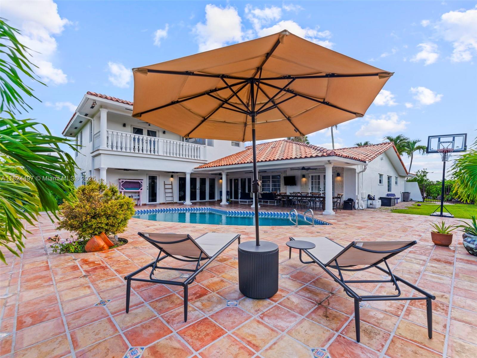 1851 Southwest 126th Court Miami, FL 33175 - Photo 41 of 85 a patio with a table and chairs under an umbrella