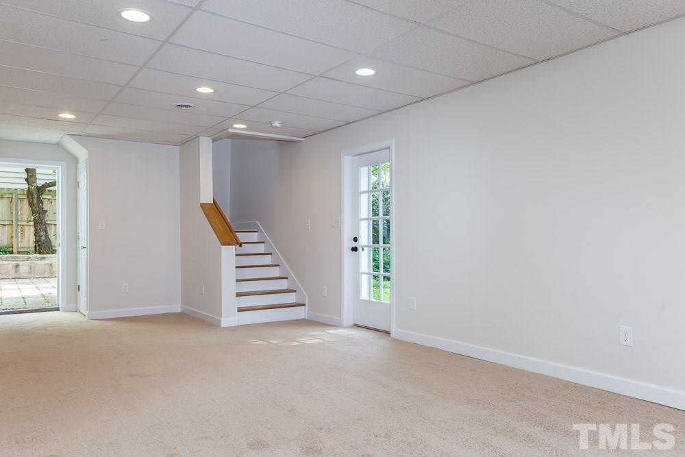 2113 Pine Drive Raleigh, NC 27608 - Photo 21 of 25 an empty room with a staircase and white walls