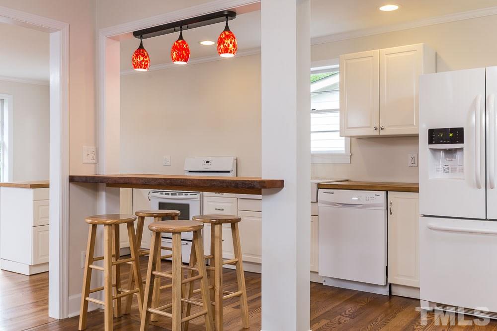 2113 Pine Drive Raleigh, NC 27608 - Photo 5 of 25 a kitchen with stainless steel appliances a refrigerator and a stove top oven