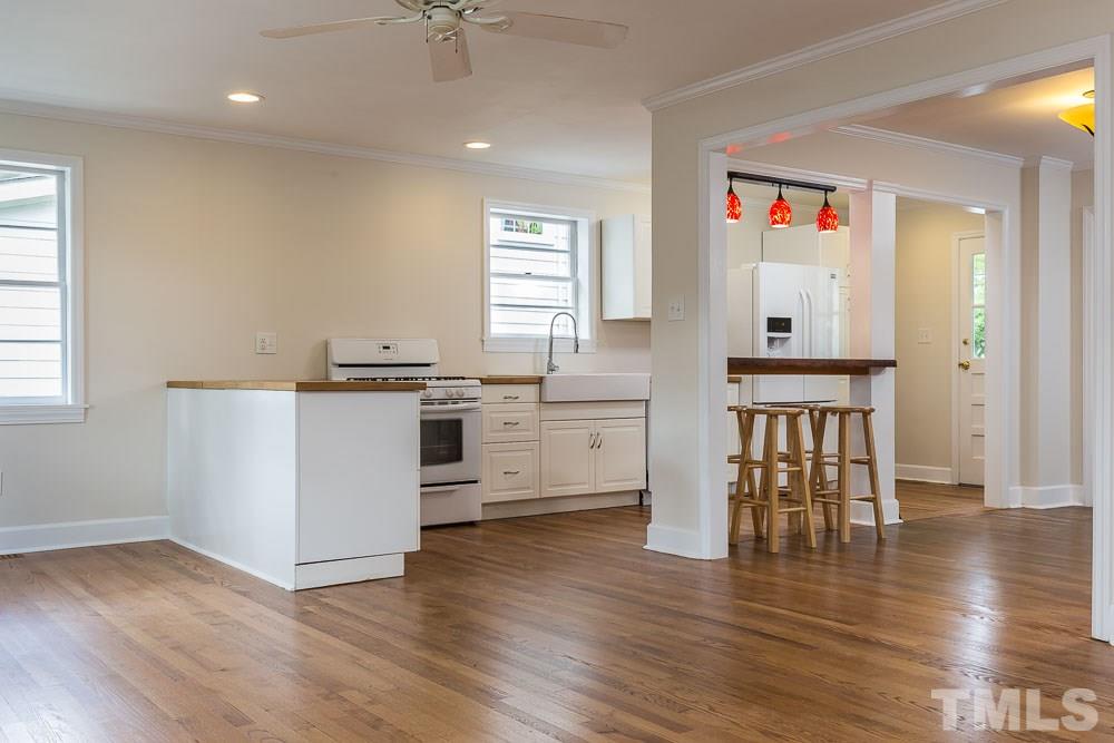2113 Pine Drive Raleigh, NC 27608 - Photo 8 of 25 a kitchen with white cabinets and wooden floor