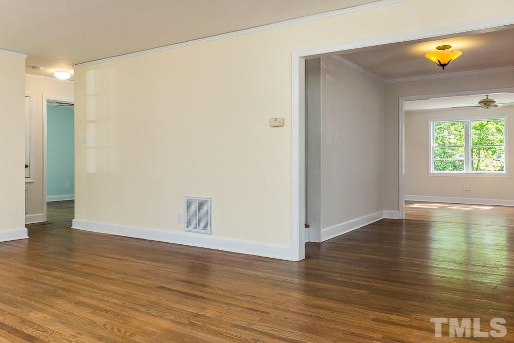2113 Pine Drive Raleigh, NC 27608 - Photo 9 of 25 a view of an empty room with window and wooden floor