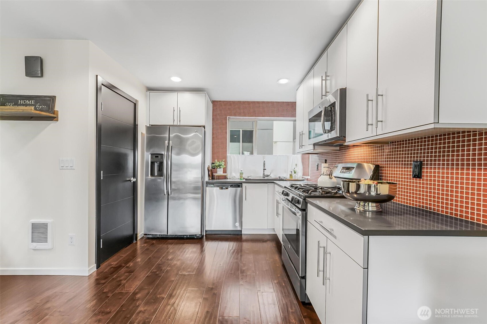 7748 Delridge Way Southwest Seattle, WA 98106 - Photo 12 of 22 a kitchen with granite countertop a refrigerator stove top oven and sink