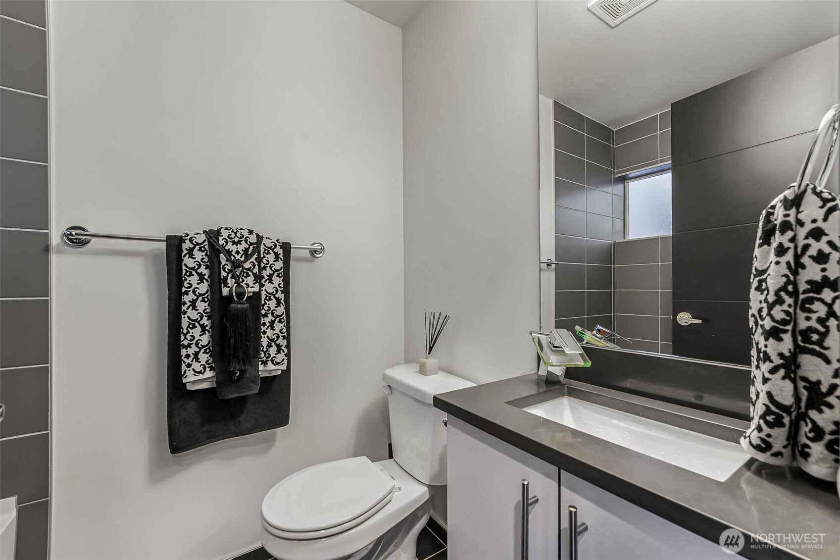 7748 Delridge Way Southwest Seattle, WA 98106 - Photo 6 of 22 a bathroom with a granite countertop toilet sink and mirror