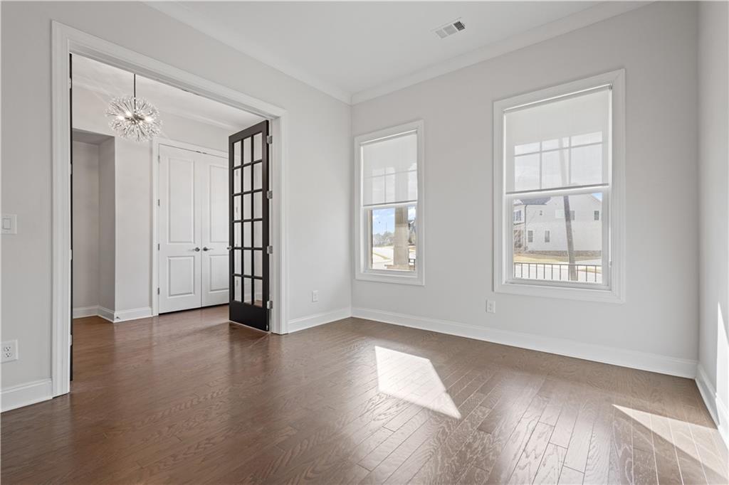 4879 Glencree Court Southwest Powder Springs, GA 30127 - Photo 13 of 47 a view of an empty room with wooden floor and a window