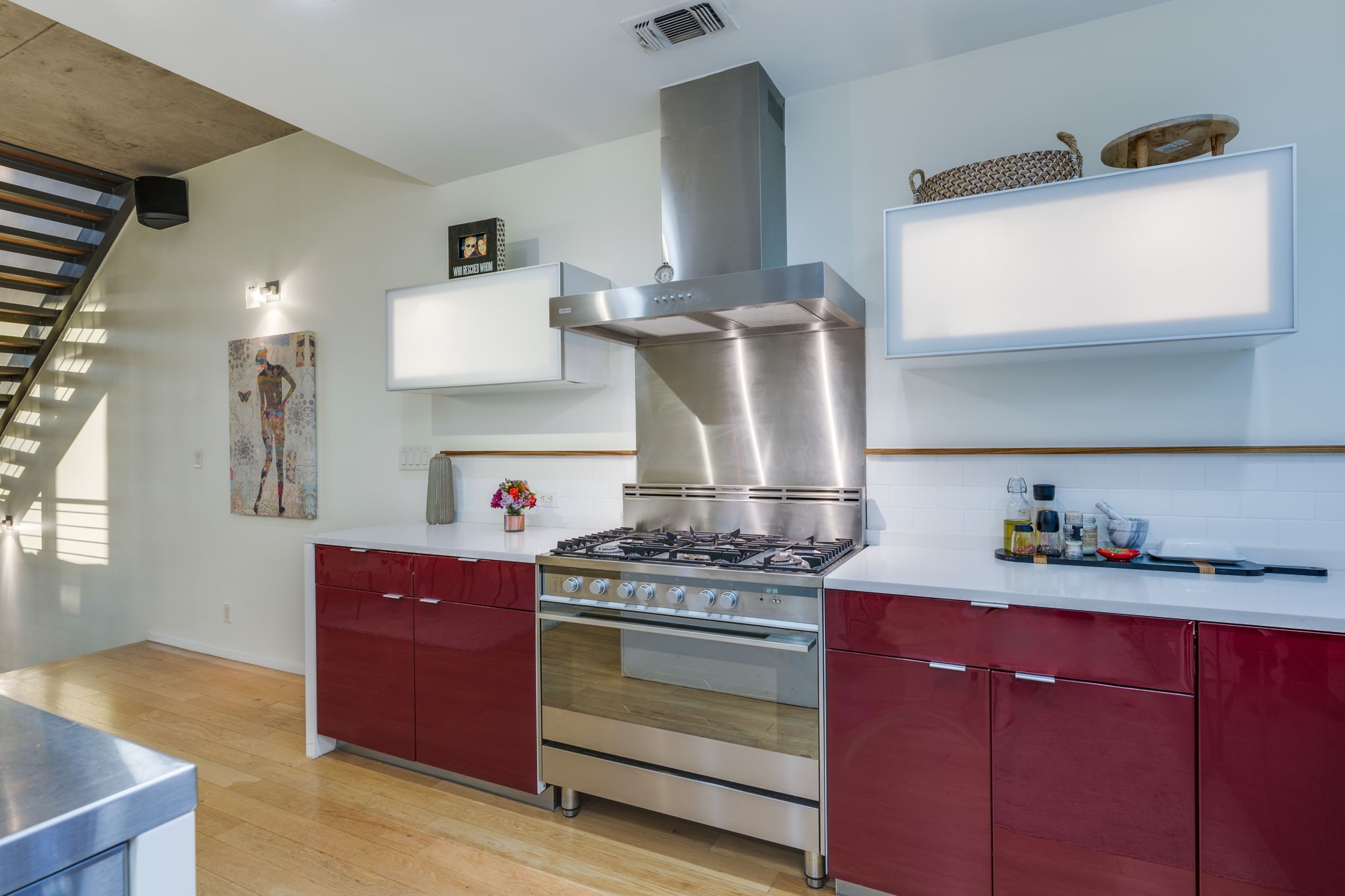 2301 South 5th Street, Unit 5 Austin, TX 78704 - Photo 16 of 39 Kitchen featuring light hardwood / wood-style flooring, stainless steel counters, decorative backsplash, gas range, and wall chimney exhaust hood