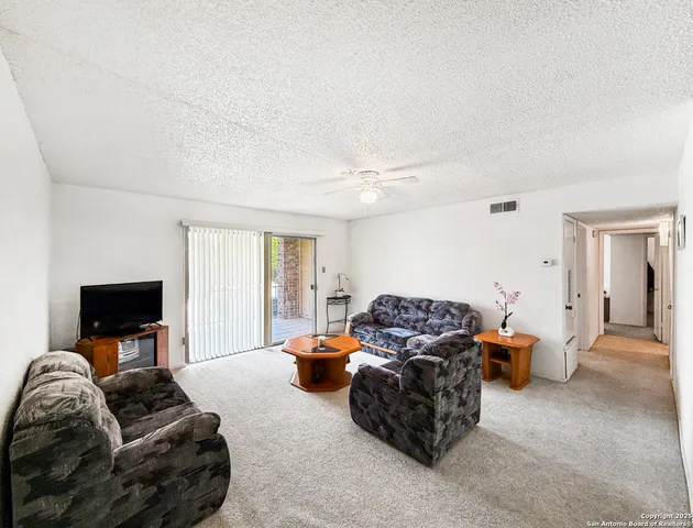 a living room with furniture a flat screen tv and a window