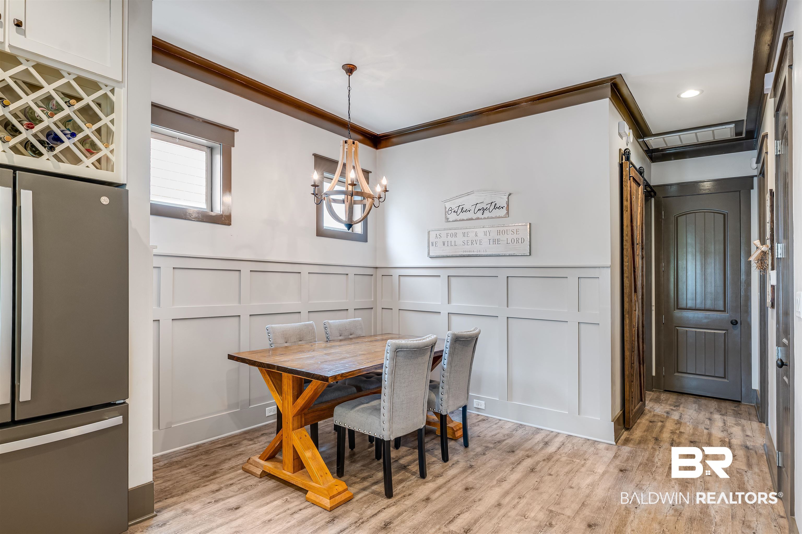 1119 Pink Poppy Lane Foley, AL 36535 - Photo 19 of 38 Dining space with a decorative wall, wainscoting, a barn door, light wood finished floors, and a chandelier