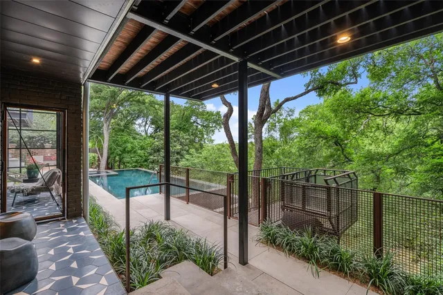 an aerial view of a house with outdoor space and trees all around
