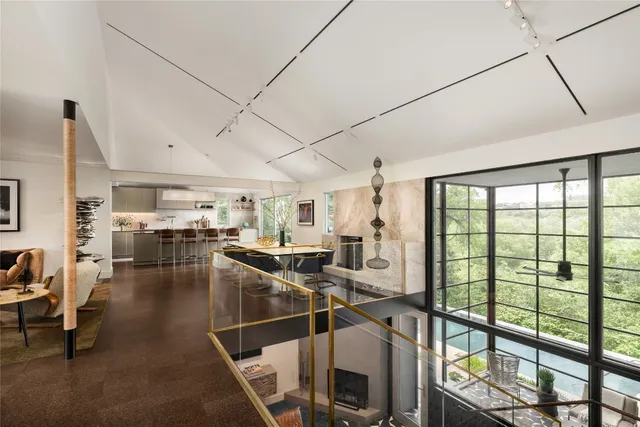 a room with stainless steel appliances kitchen island granite countertop a table chairs in it and wooden floors