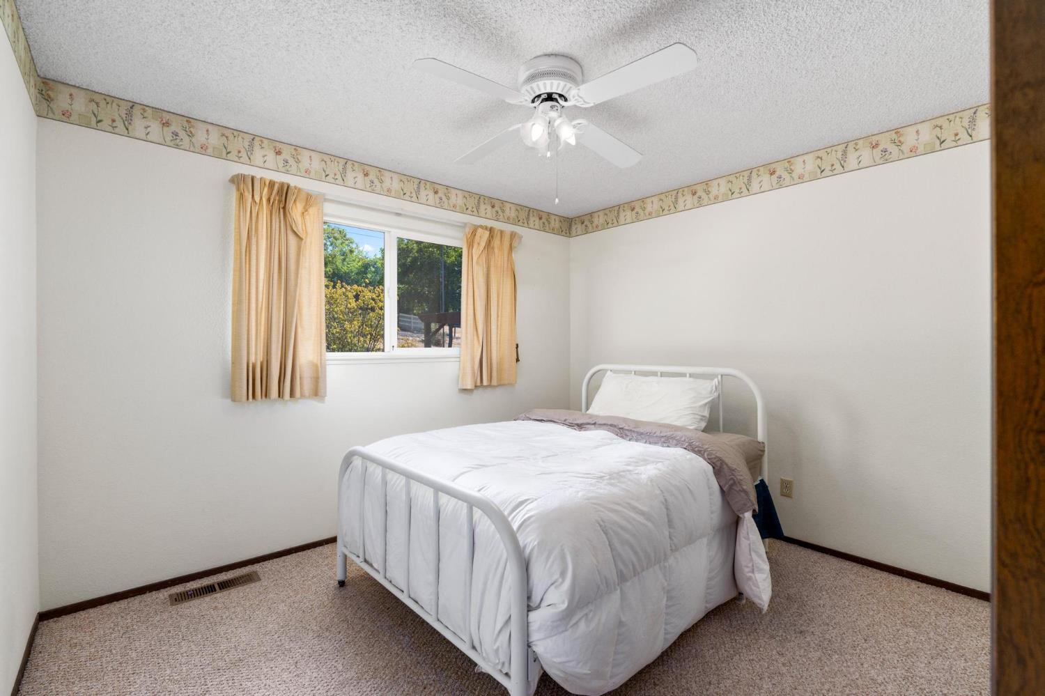 18490 Railbed Road Jamestown, CA 95327 - Photo 28 of 53 a bedroom with a bed and a ceiling fan
