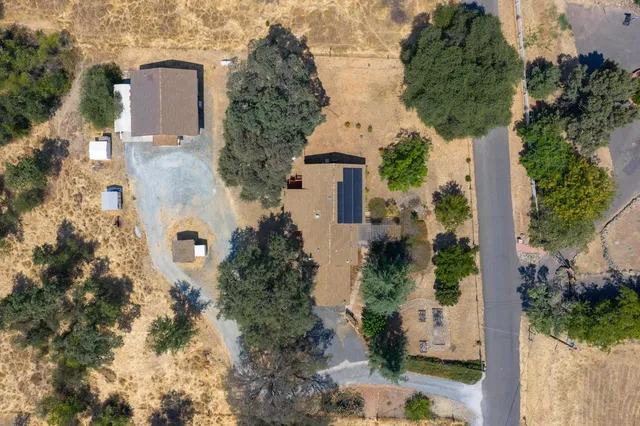 an aerial view of a house with yard and outdoor seating