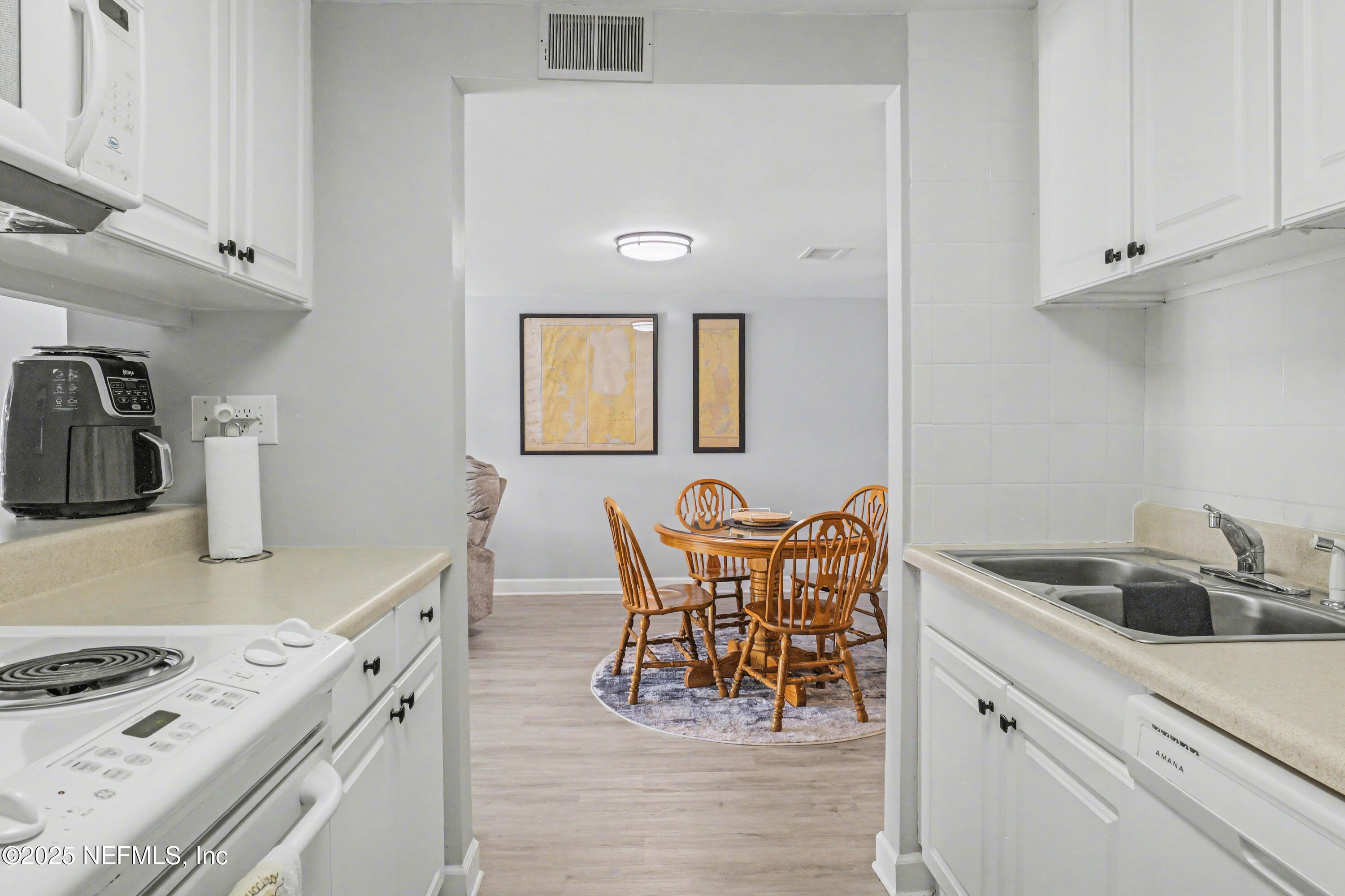 102 River Bend Road, Unit A Welaka, FL 32193 - Photo 23 of 39 a kitchen with stainless steel appliances granite countertop a stove a sink and a white cabinets