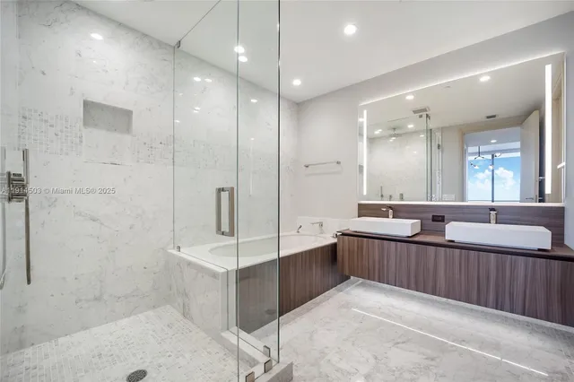 a large bathroom with a double vanity sink a large mirror and shower