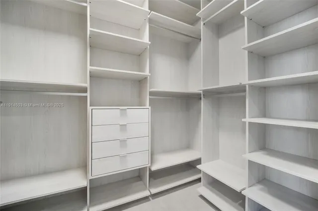 a view of walk in closet with empty racks