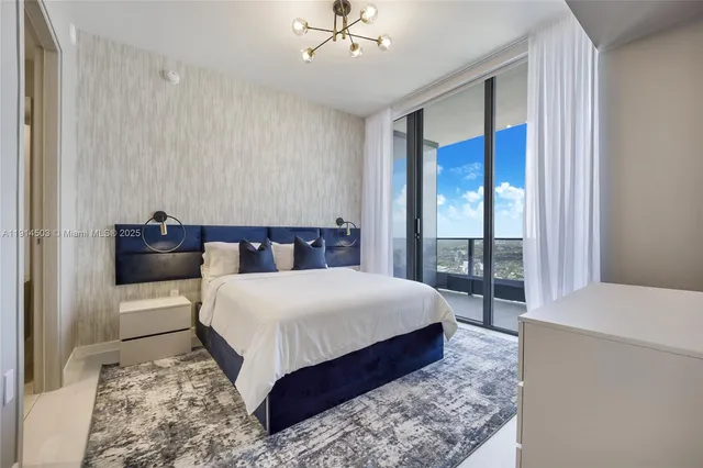 a spacious bedroom with a large bed and a chandelier