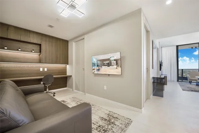 a living room with furniture and view of kitchen
