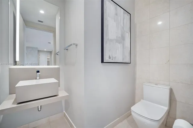 a bathroom with a sink a toilet and mirror