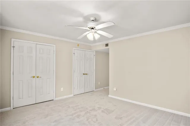 an empty room with closet and a ceiling fan