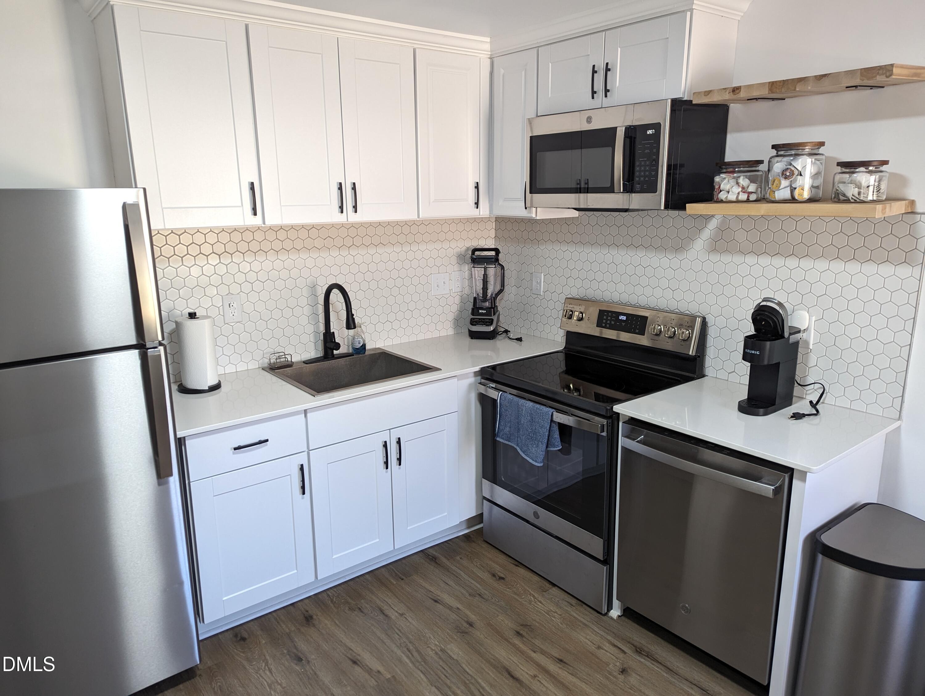 4816 Whitehall Avenue Raleigh, NC 27604 - Photo 13 of 23 a kitchen with stainless steel appliances granite countertop a sink stove and refrigerator