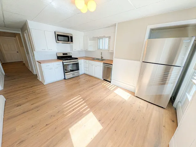 a kitchen with a refrigerator a stove top oven and sink