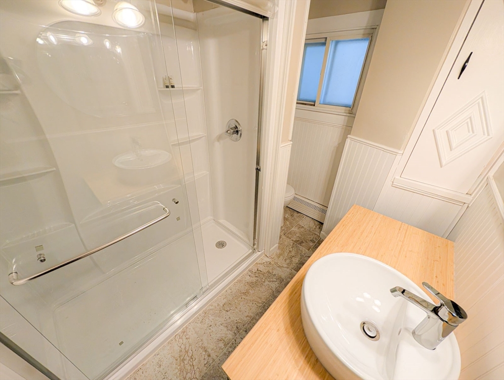 103-105 Homer Street, Unit 1 Boston, MA 02128 - Photo 9 of 17 a bathroom with a tub sink and mirror