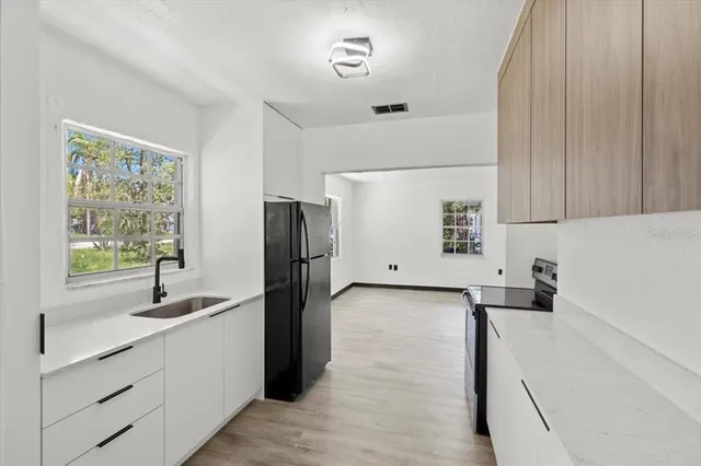 a kitchen with a refrigerator and a sink
