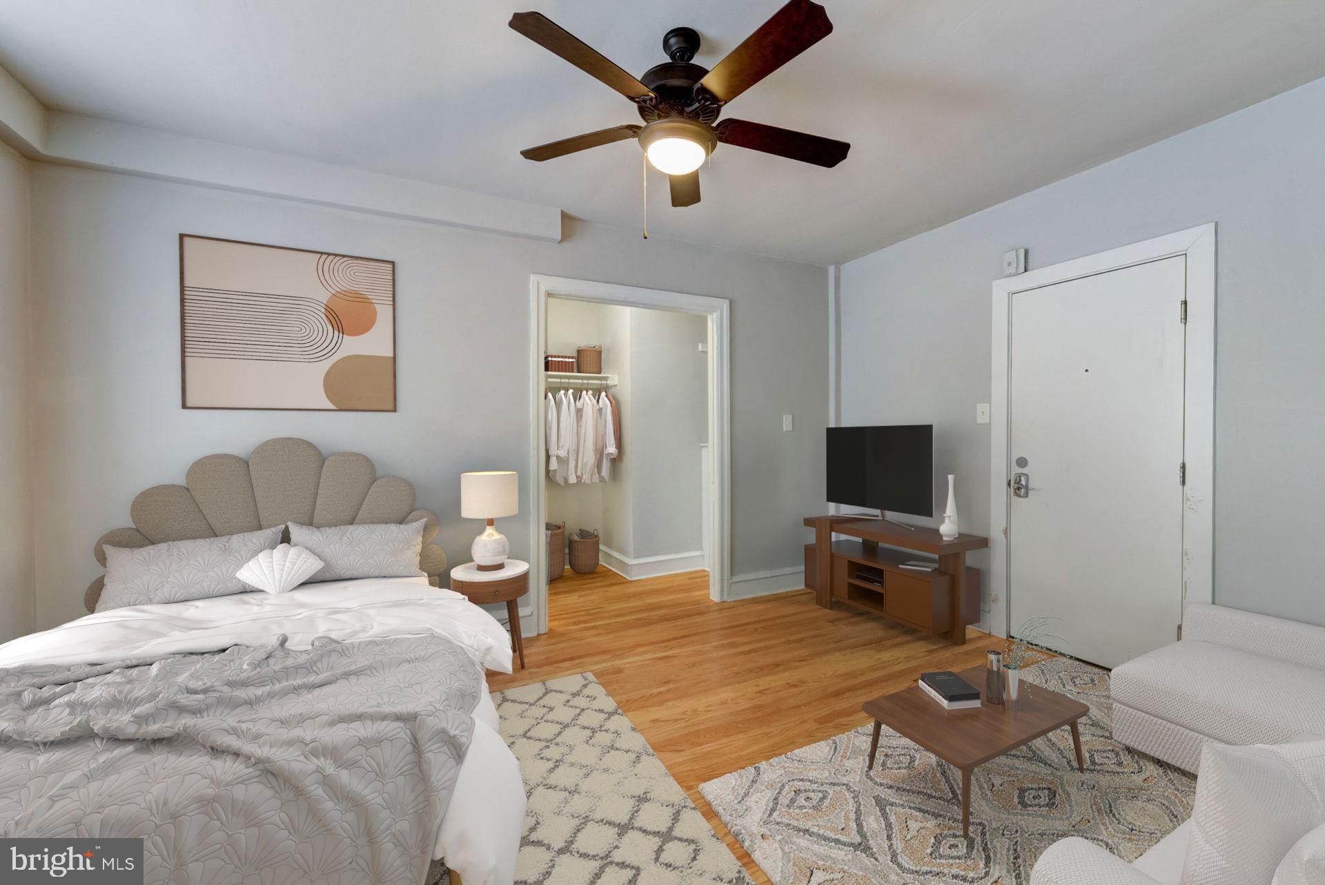 4605 Chester Avenue, Unit STUDIO Philadelphia, PA 19143 - Photo 9 of 12 a bedroom with a bed and a flat screen tv