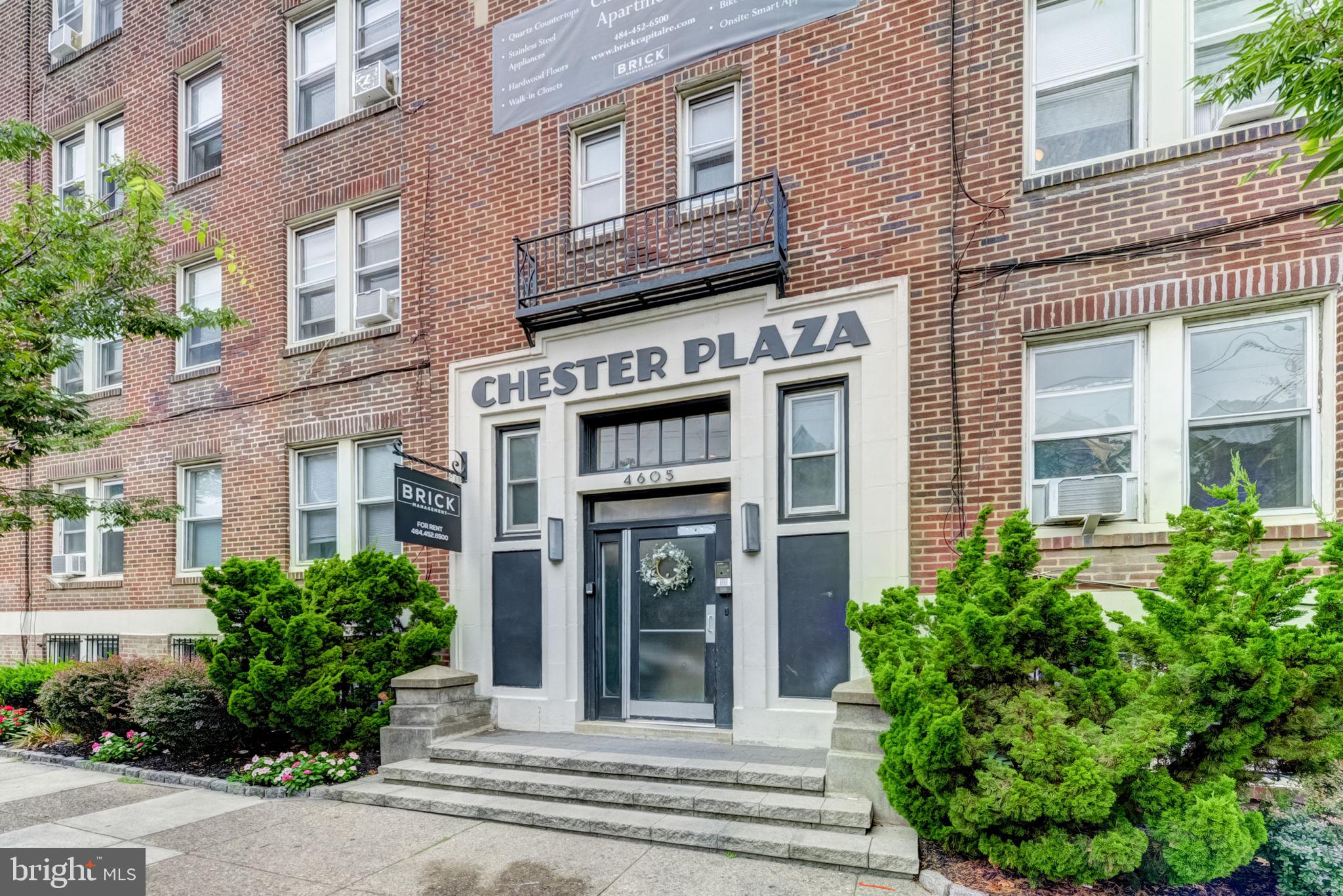 4605 Chester Avenue, Unit STUDIO Philadelphia, PA 19143 - Photo 10 of 12 a view of a brick building with potted plants