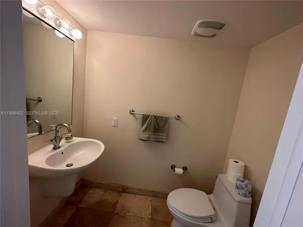 a bathroom with a sink a toilet and mirror