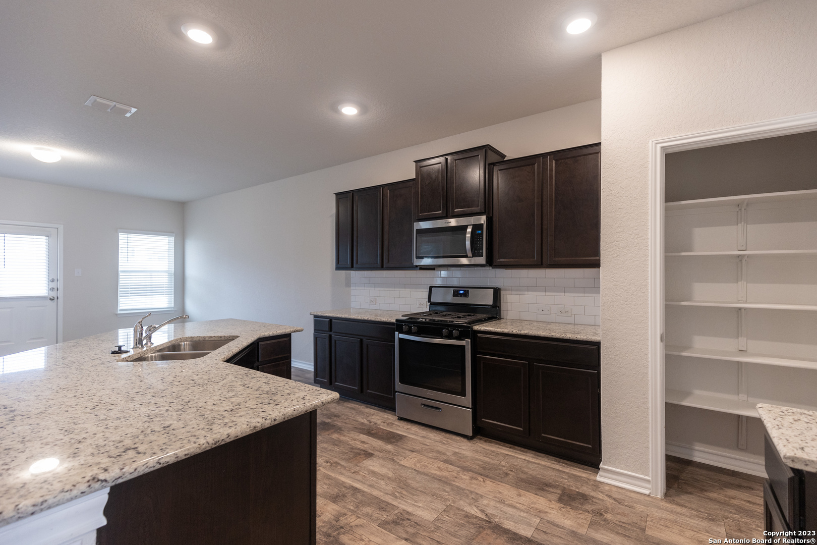 9819 Bratten Rise San Antonio, TX 78254 - Photo 10 of 37 a kitchen with granite countertop cabinets stainless steel appliances and a counter space