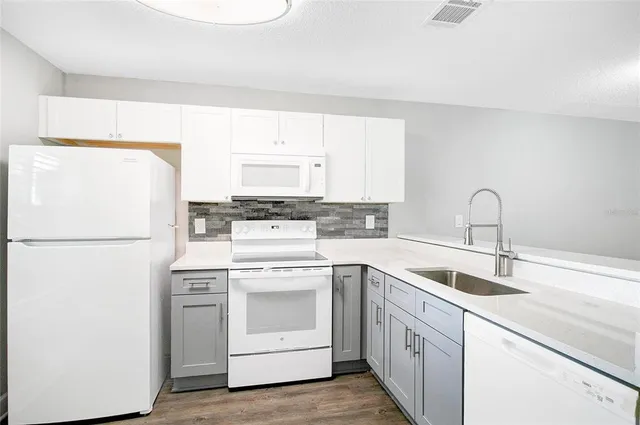 a kitchen with white cabinets sink and white appliances
