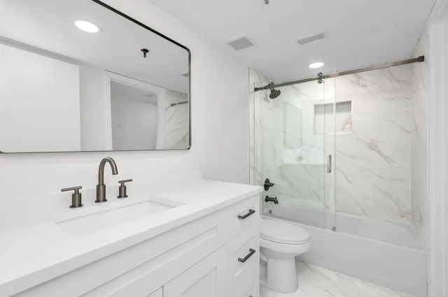 a bathroom with a sink a toilet and shower