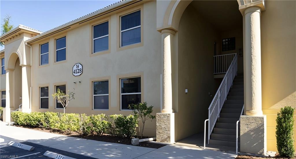4128 Bellasol Circle, Unit 1423 Fort Myers, FL 33916 - Photo 2 of 6 a front view of a house with a yard