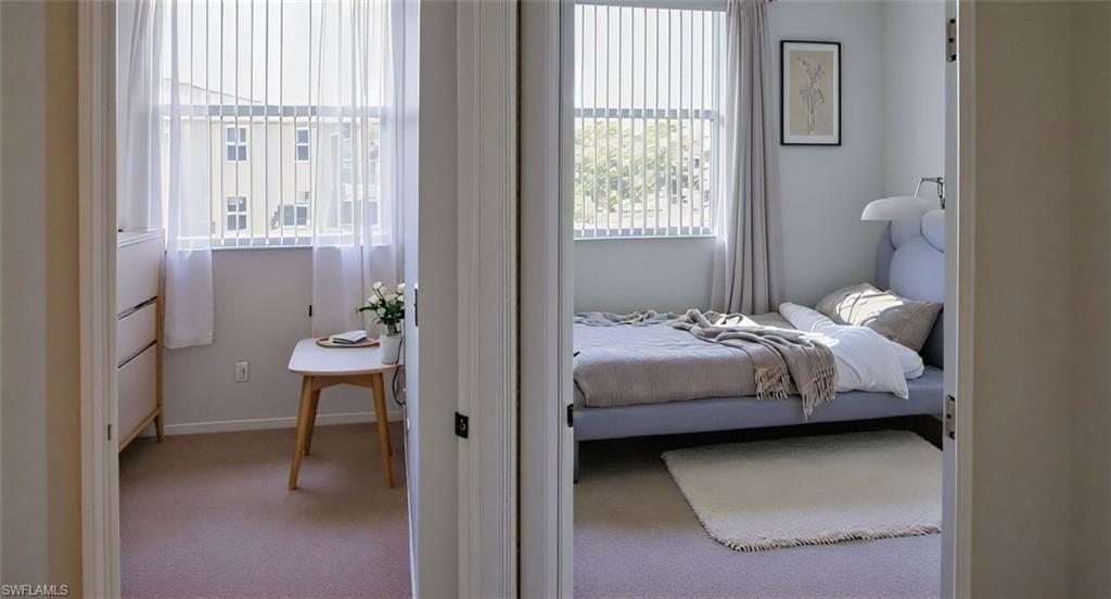 4128 Bellasol Circle, Unit 1423 Fort Myers, FL 33916 - Photo 5 of 6 a bedroom with a bed and a table next to a window