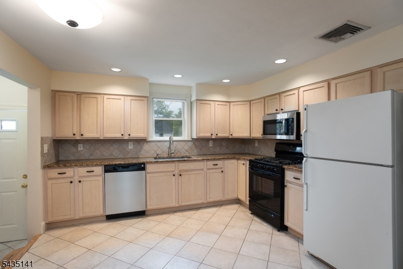 14 Locust Street Madison, NJ 07940 - Photo 19 of 33 a kitchen with stainless steel appliances granite countertop a refrigerator sink and white cabinets