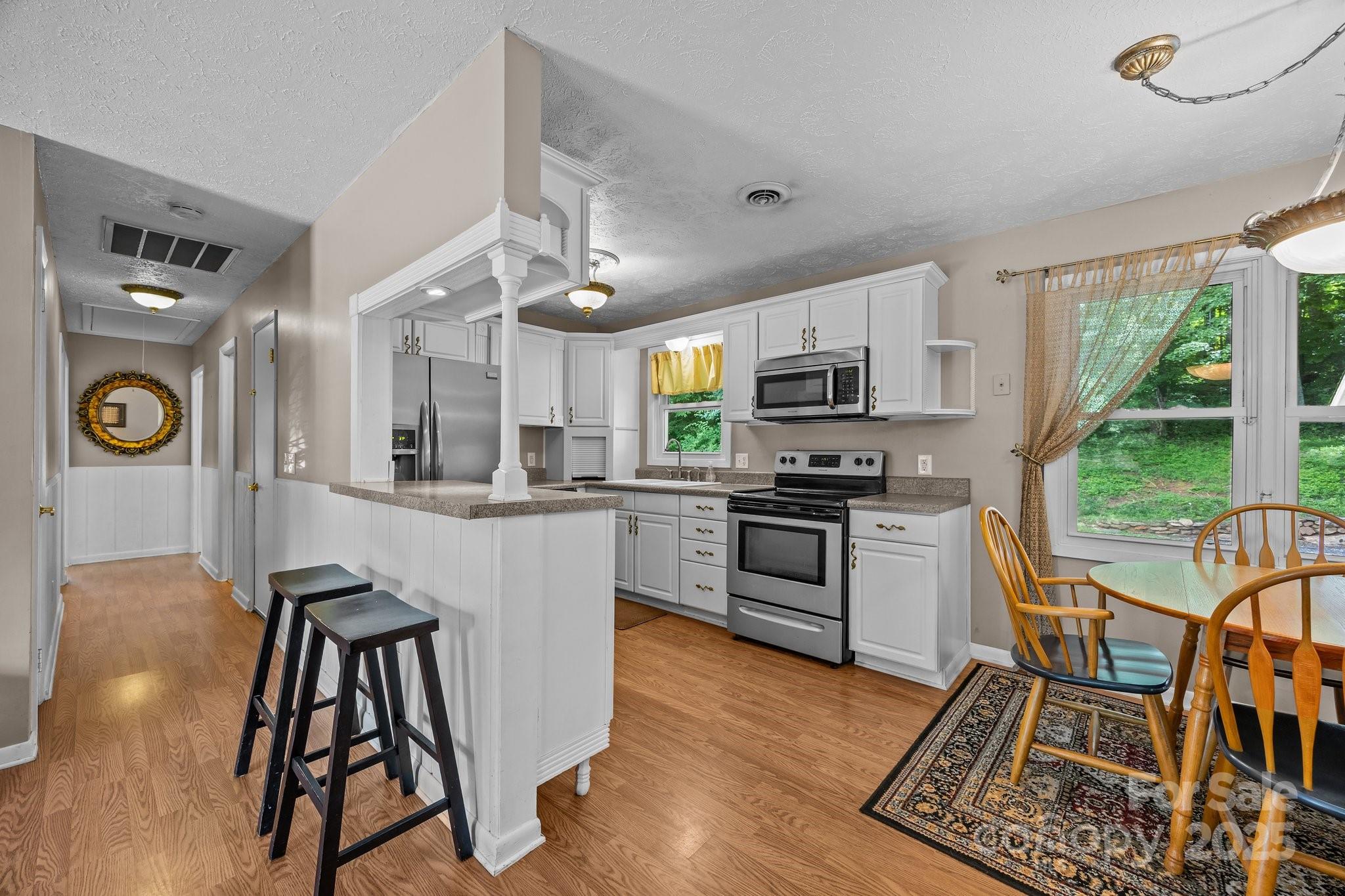 64 Christopher Lane Sylva, NC 28779 - Photo 12 of 31 a kitchen with stainless steel appliances granite countertop a refrigerator a stove top oven a sink dishwasher and white cabinets with wooden floor