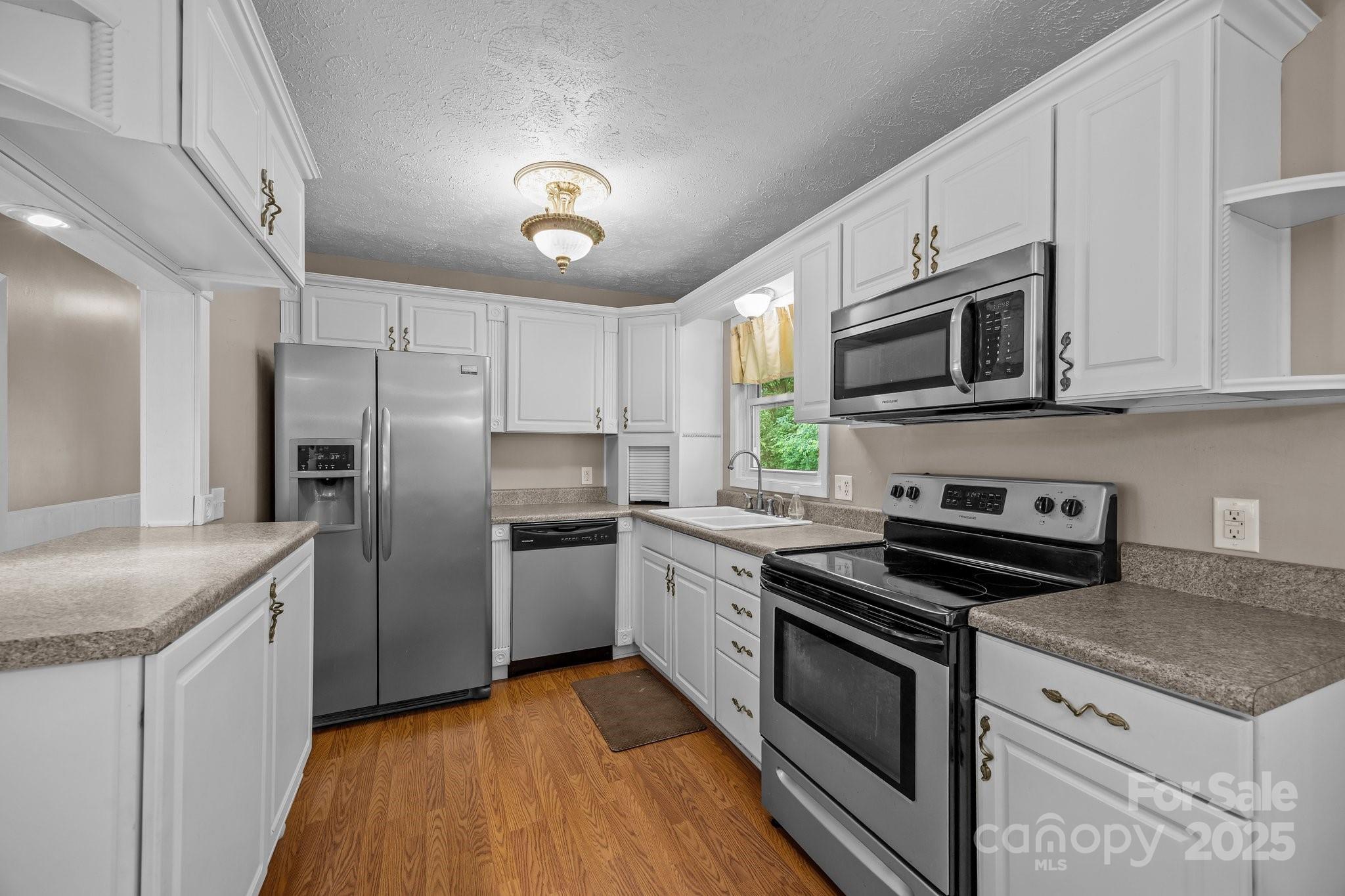 64 Christopher Lane Sylva, NC 28779 - Photo 14 of 31 a kitchen with stainless steel appliances granite countertop a sink stove microwave and refrigerator