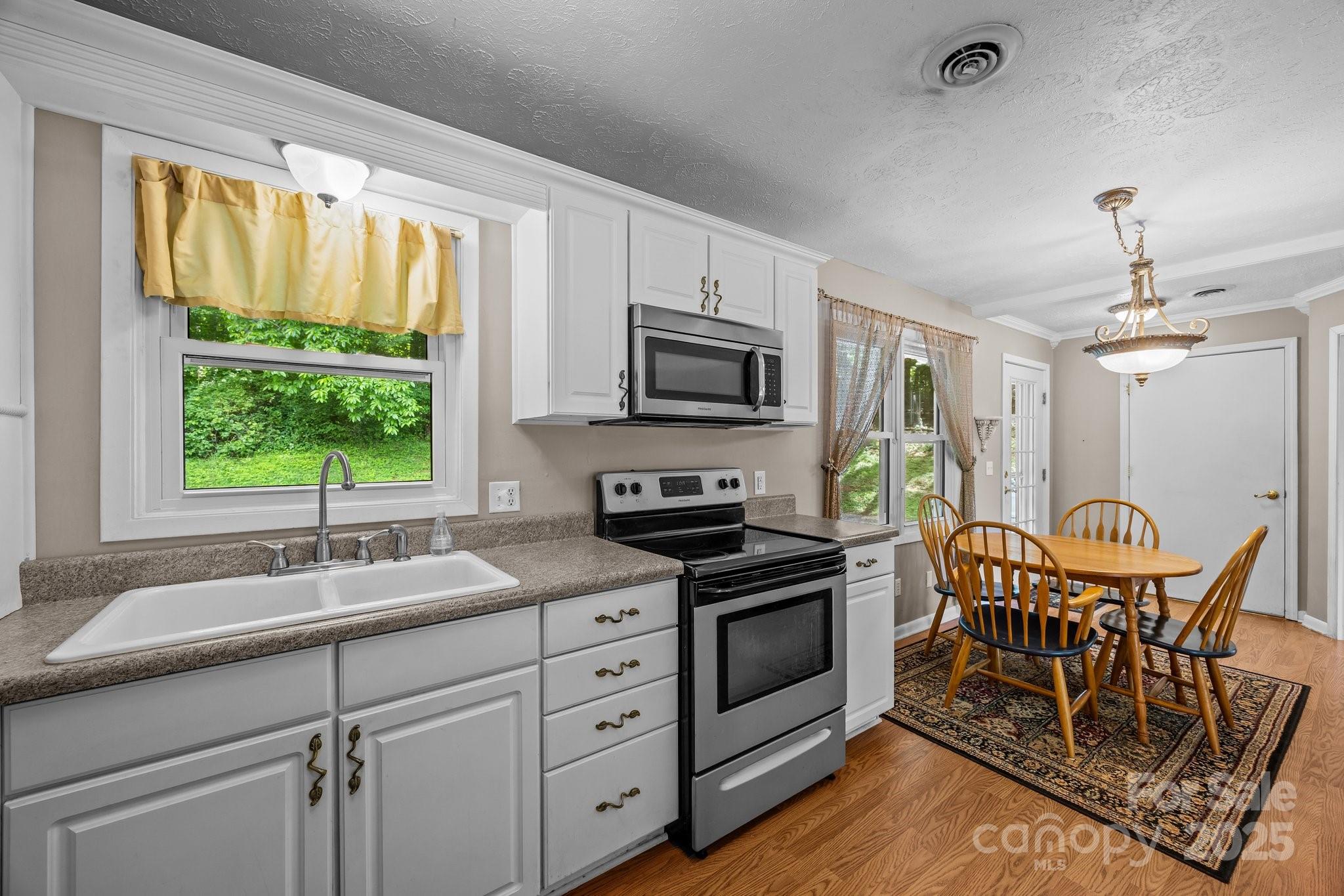 64 Christopher Lane Sylva, NC 28779 - Photo 15 of 31 a kitchen with stainless steel appliances granite countertop a stove top oven a sink a dining table and chairs