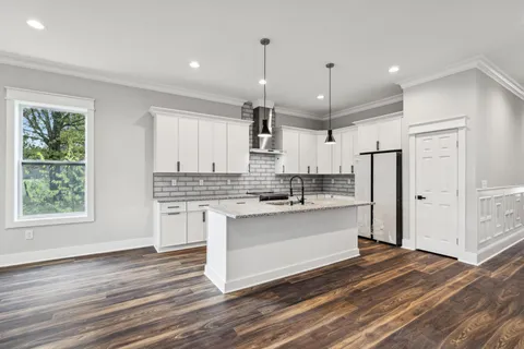 a kitchen with white cabinets sink and stainless steel appliances