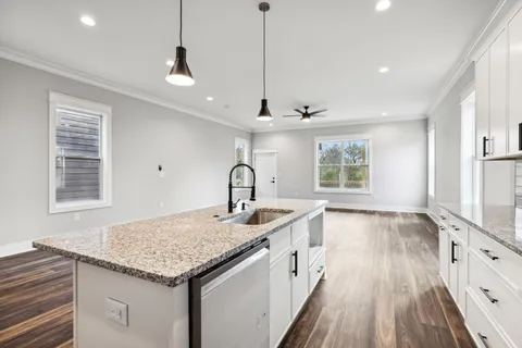 a kitchen with stainless steel appliances a refrigerator sink and white cabinets