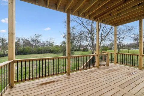 an empty room with wooden floor and a ceiling fan