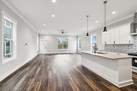 a kitchen with kitchen island white cabinets and wooden floor