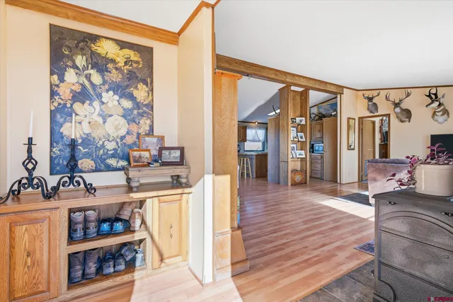 a living room with stainless steel appliances furniture a rug and a large window