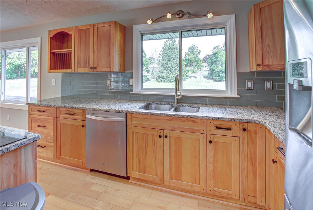 12477 Webster Road Strongsville, OH 44136 - Photo 14 of 40 Kitchen with a healthy amount of sunlight, stainless steel appliances, sink, and light hardwood / wood-style floors