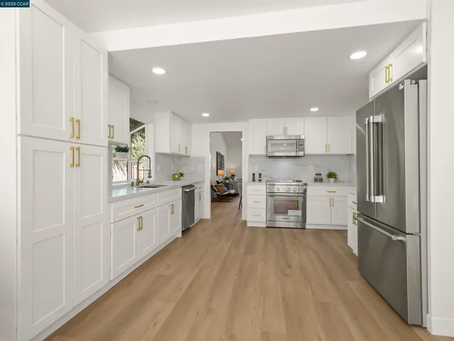 a kitchen with white cabinets and stainless steel appliances