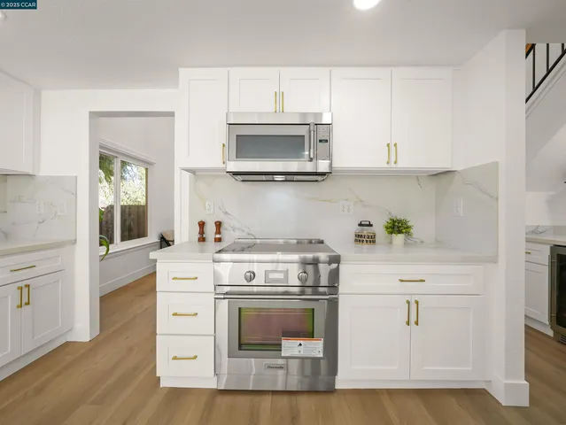 a kitchen with white cabinets and white appliances