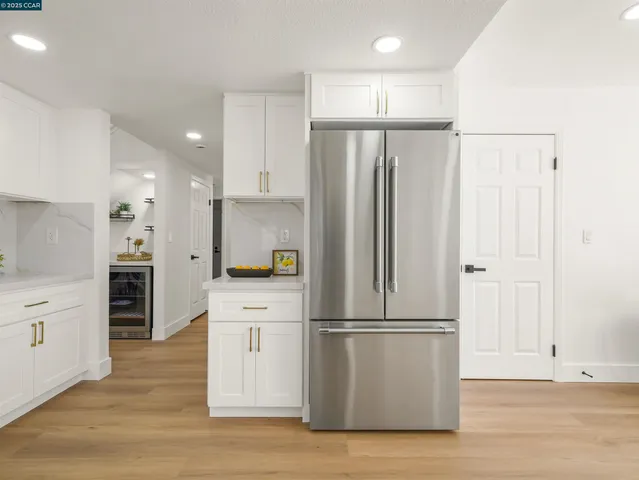 a kitchen with kitchen island white cabinets stainless steel appliances and wooden floor
