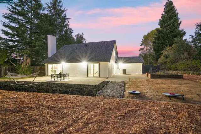 a front view of a house with a yard and trees