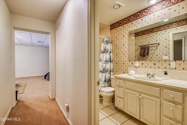 a spacious bathroom with a toilet sink double vanity and mirror