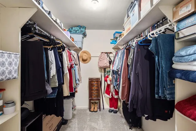 a view of walk in closet with clothes and shoes